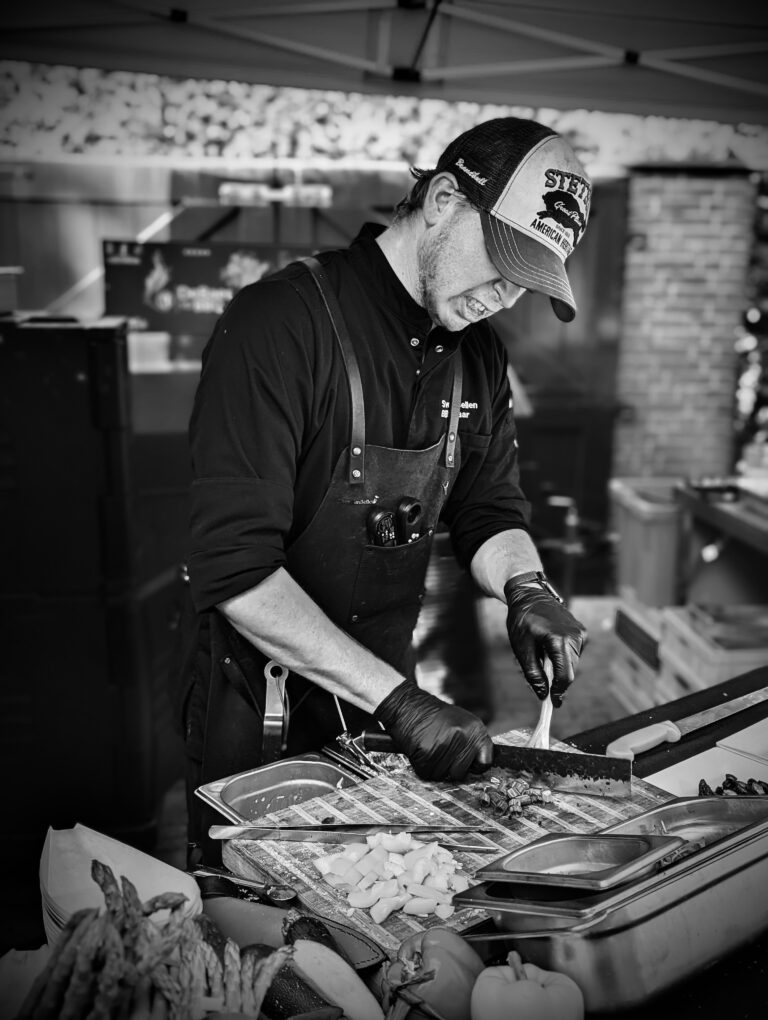 Sven van DeBaes van de BBQ bereidt vlees aan de werktafel.